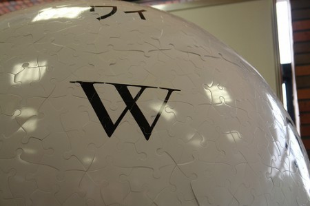 Der obere Teil eines weißen Balls aus Puzzleteilen, in der Mitte ein großes W (aus dem Wikipedia-Logo)